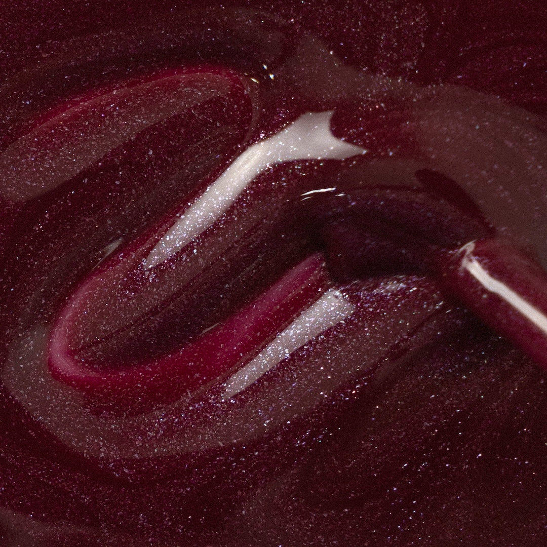 Berry Night Sky Nail Polish – Nahaufnahme des Farbmusters; Farbton ein sattes, weinartig dunkles Beerenrot mit seidigem Sternenschimmer